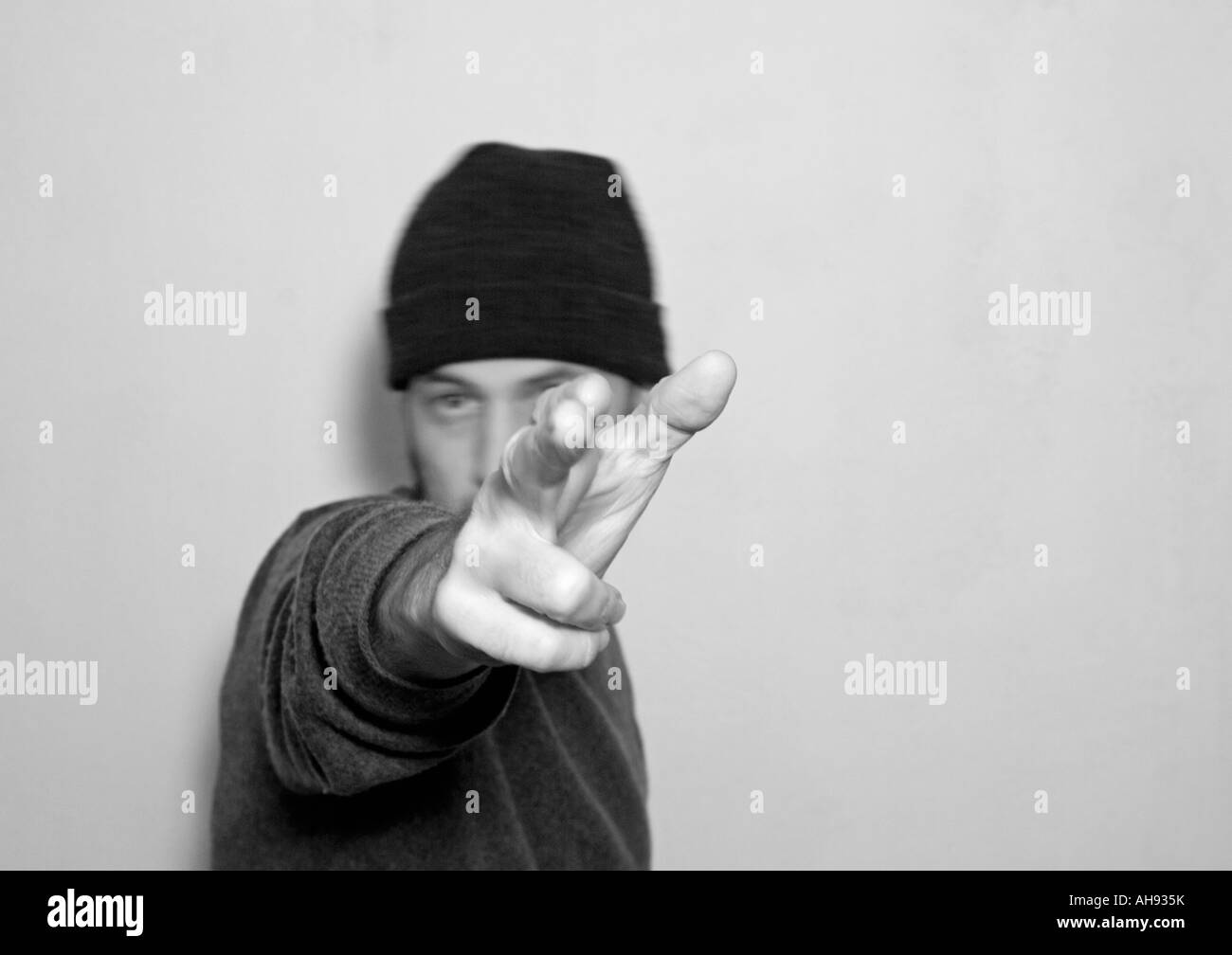 a bw photo of young man with hat doing click banging gesture Stock Photo
