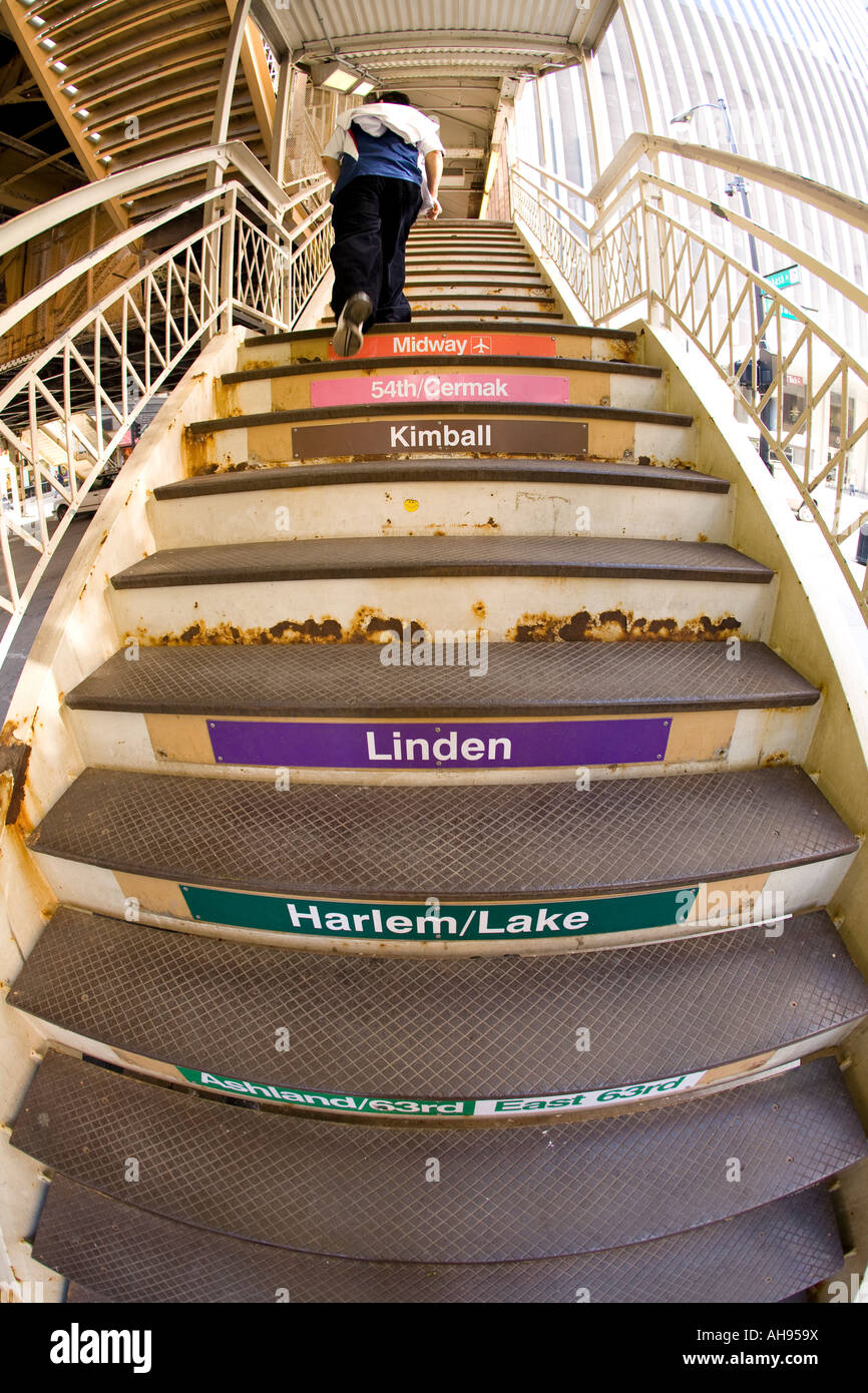 ILLINOIS Chicago Young man walk up el train stairs names of stops on step risers fisheye view from behind Stock Photo
