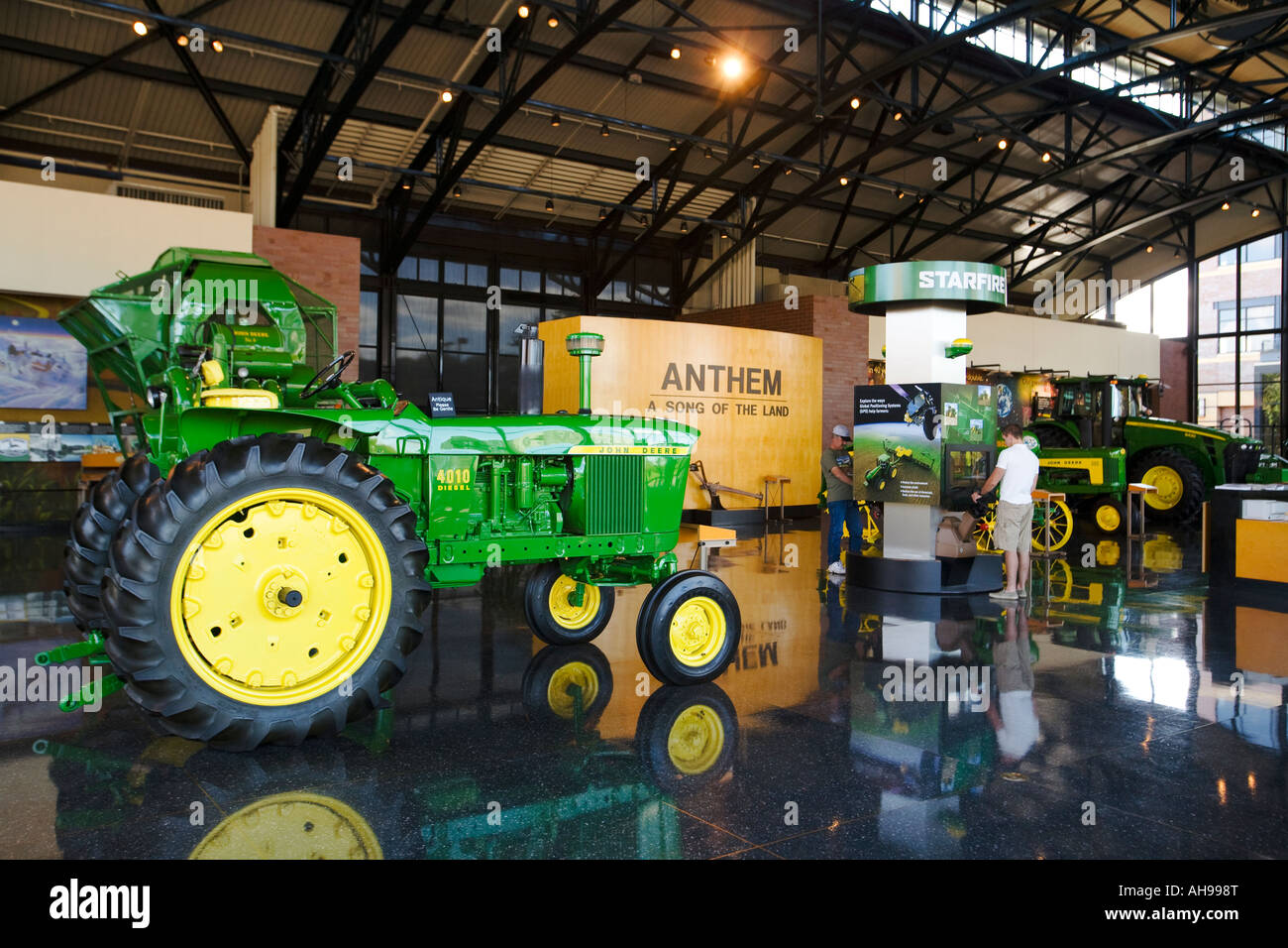 ILLINOIS Moline Visitors at interactive kiosks inside John Deere Pavilion tractors and machinery on display Stock Photo