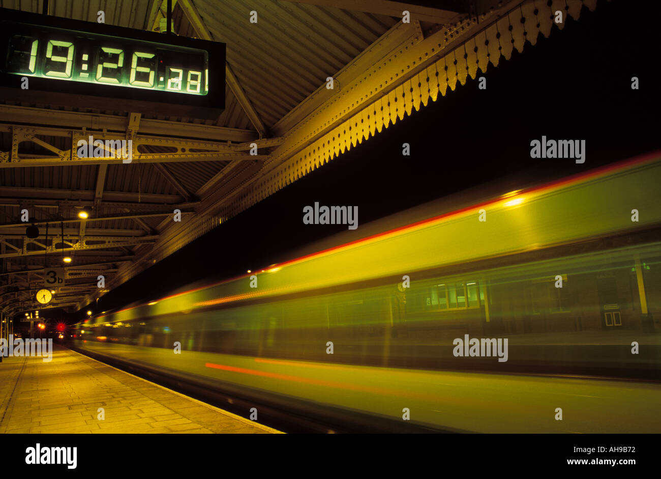 Train leaving Nottingham railway station with clock showing departure time England UK GB Europe Stock Photo