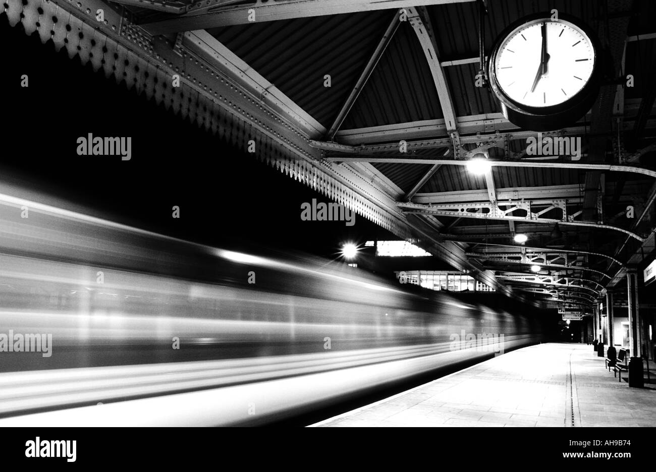 Station Clock showing Seven o'clock,time of departure for speeding train from an empty station platform Nottingham station England, UK,GB, Europe Stock Photo