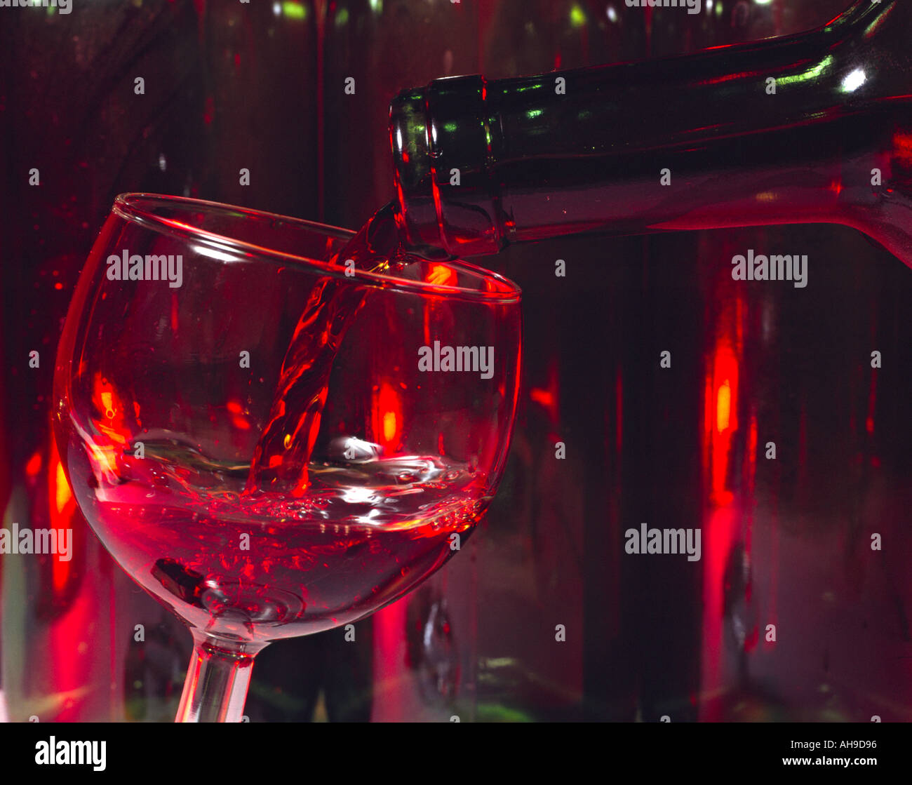 pouring red wine out of a bottle in a glass Stock Photo