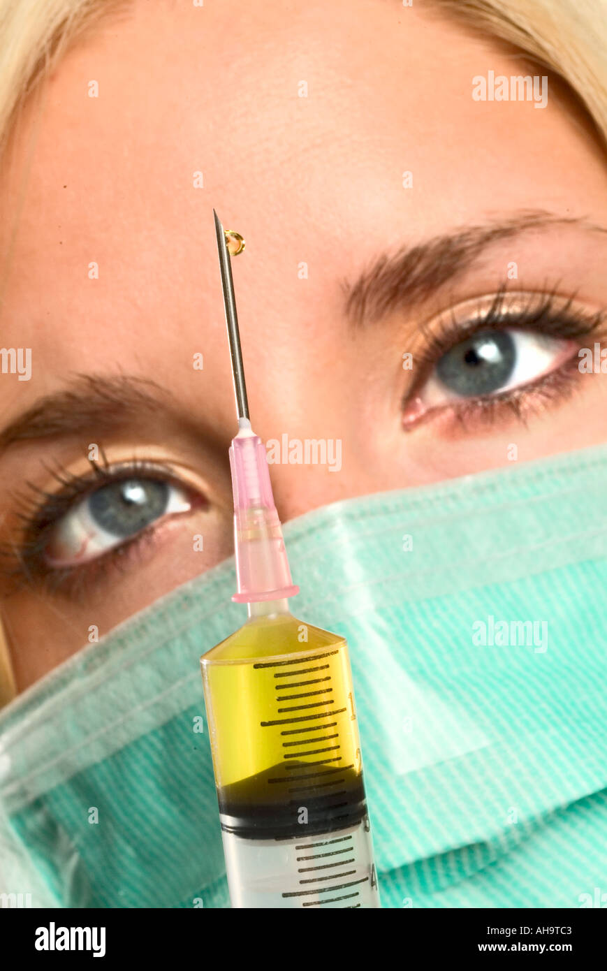 Doctor looking at syringe Stock Photo