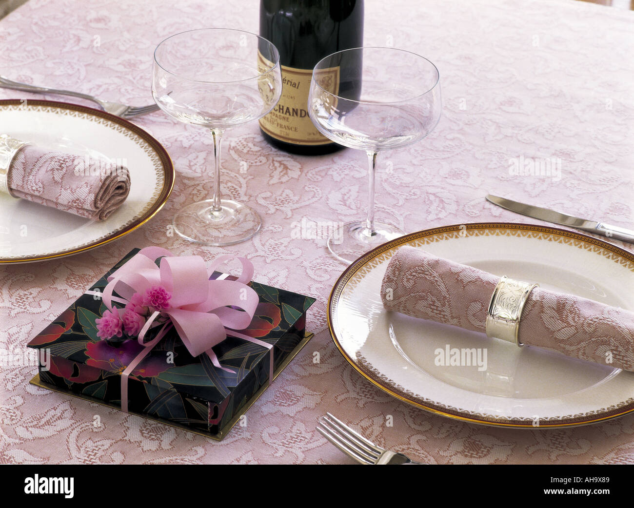 Table setting for two and a gift box Stock Photo - Alamy