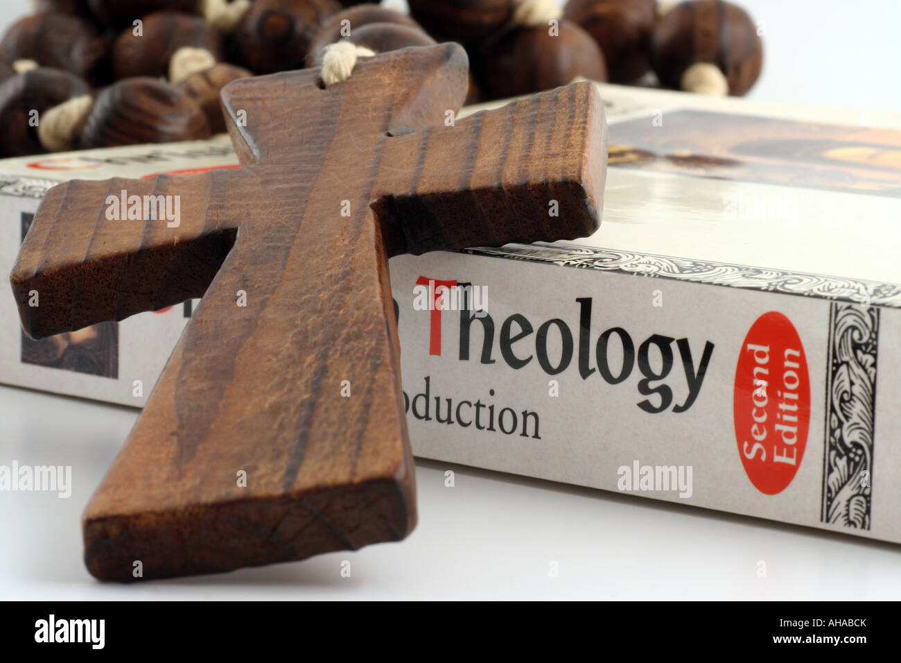 Wooden cross and textbook on Christian Theology. Stock Photo