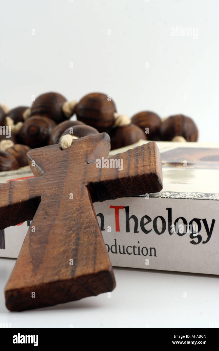 Wooden cross and textbook on Christian Theology. Stock Photo