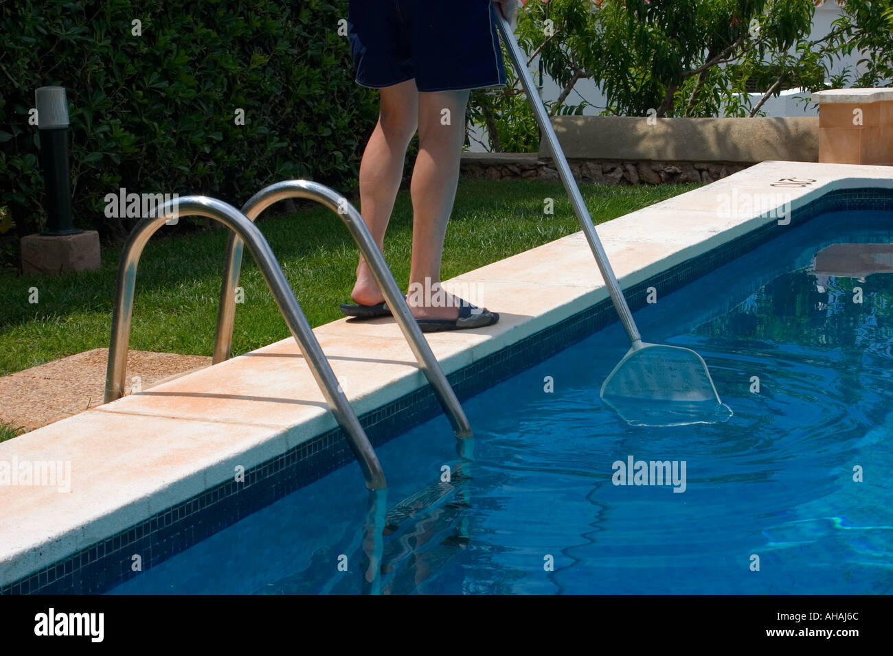 Skimming swimming pool surface with filter net. Employment abroad Stock