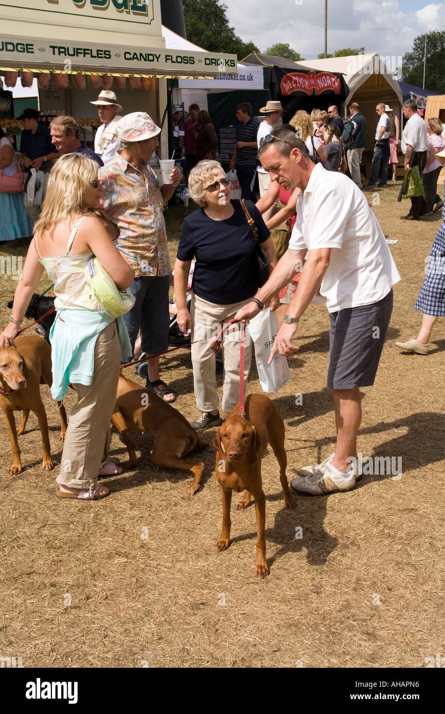 UK Hampshire Romsey Broadlands CLA Game Fair families with dogs chatting in Food Village Stock Photo