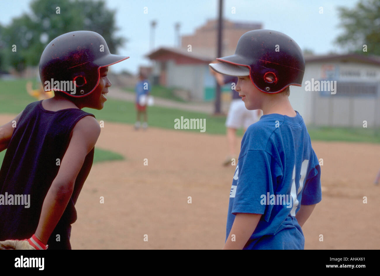 Racially mixed kids playing baseball hires stock photography and