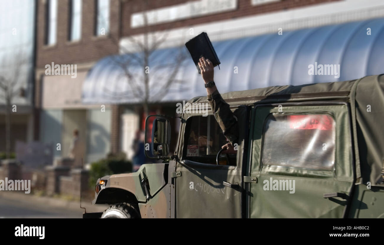 Soldier Driving Humvee Holds up Bible Out Window USA Stock Photo