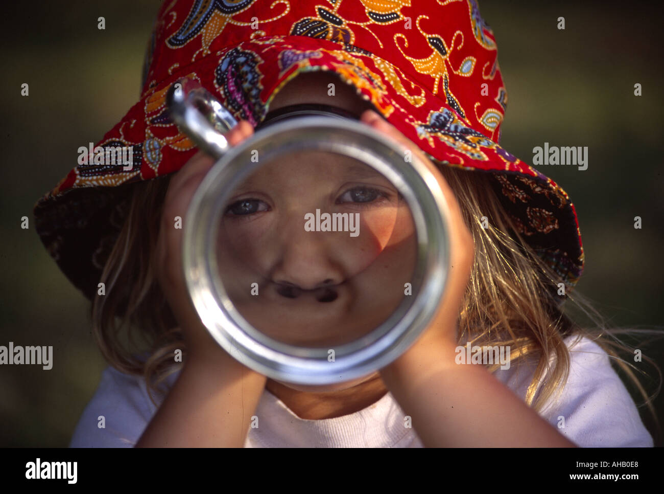 Child looking through glass bottomed pewter tankard Stock Photo