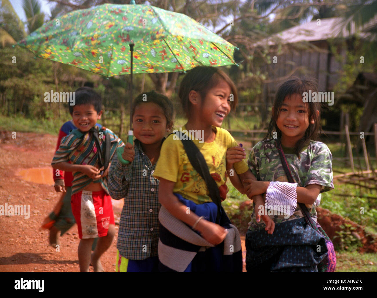 Portrait school girl boy look walk go run smile laugh happy umbrella colour sun shade Luang Prabang Laos Southeast Asia Stock Photo
