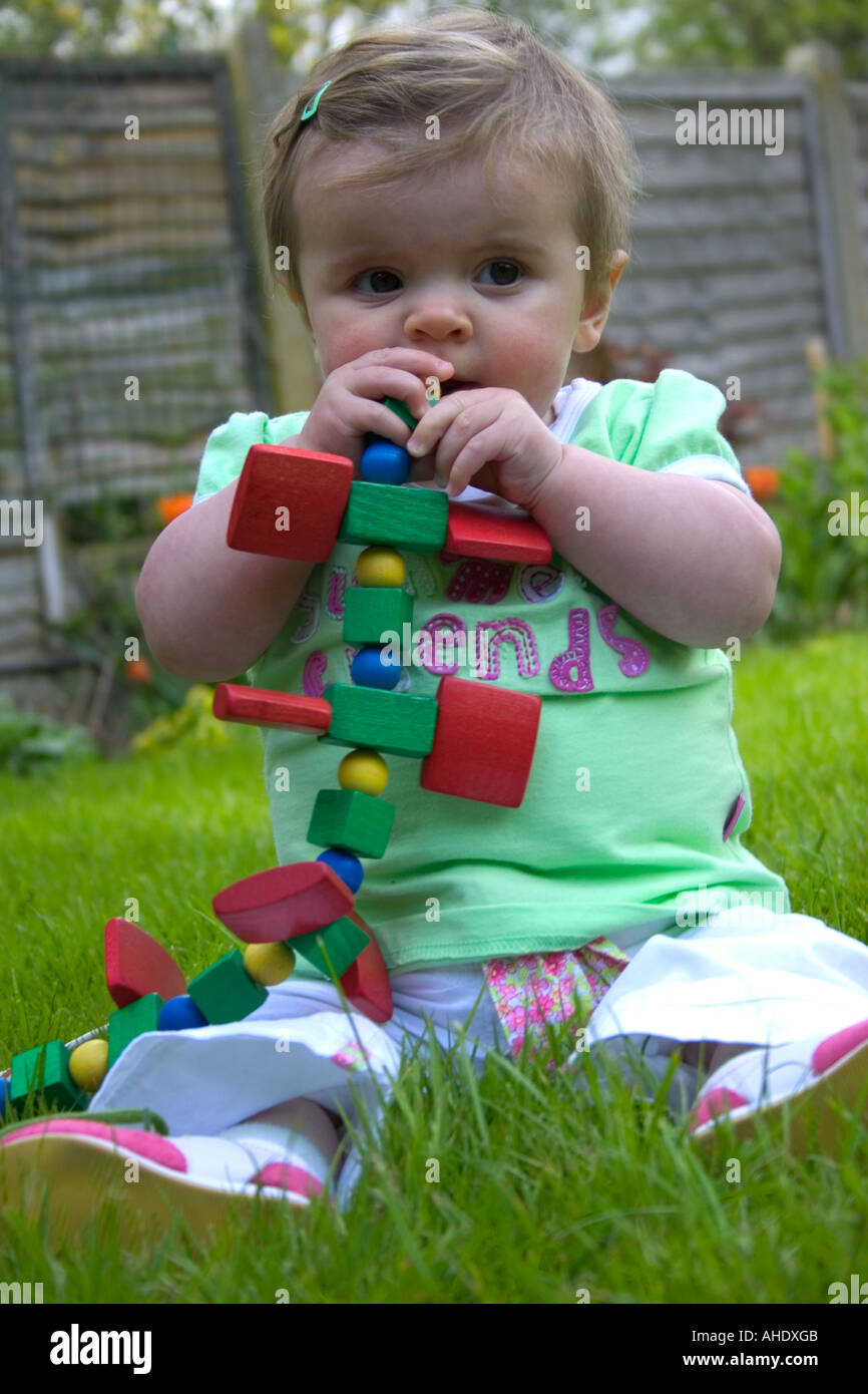 7 month old baby playing with wooden toy caterpillar Stock Photo Alamy