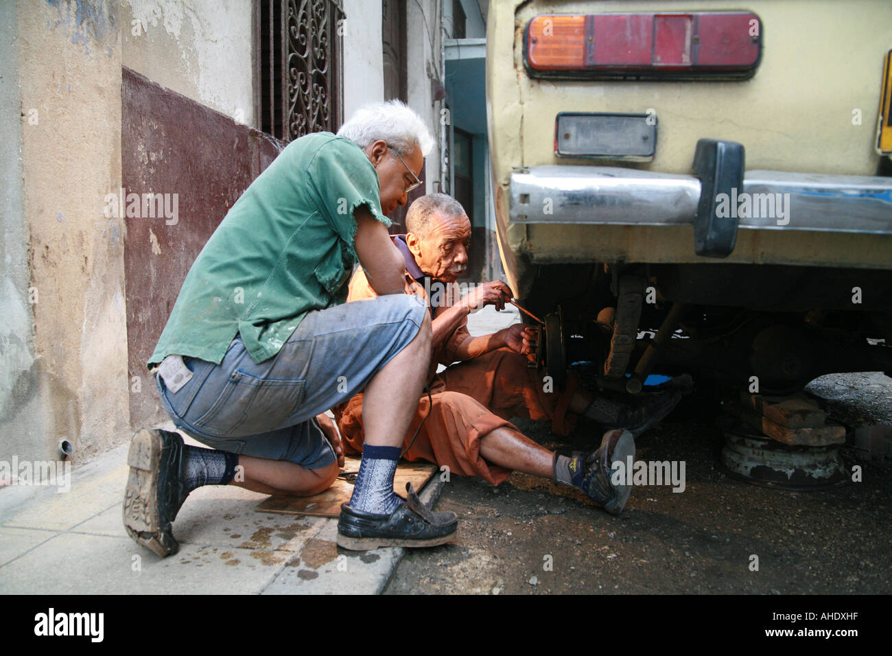 La Habana Cuba two seniors working on a lada Stock Photo