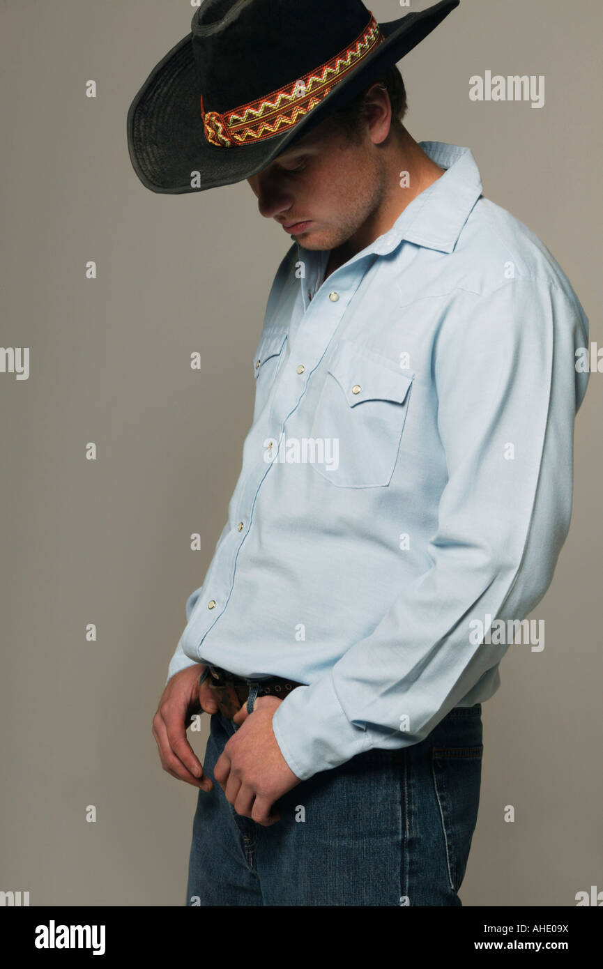 Cowboy looking down with thumbs in belt loops Stock Photo Alamy