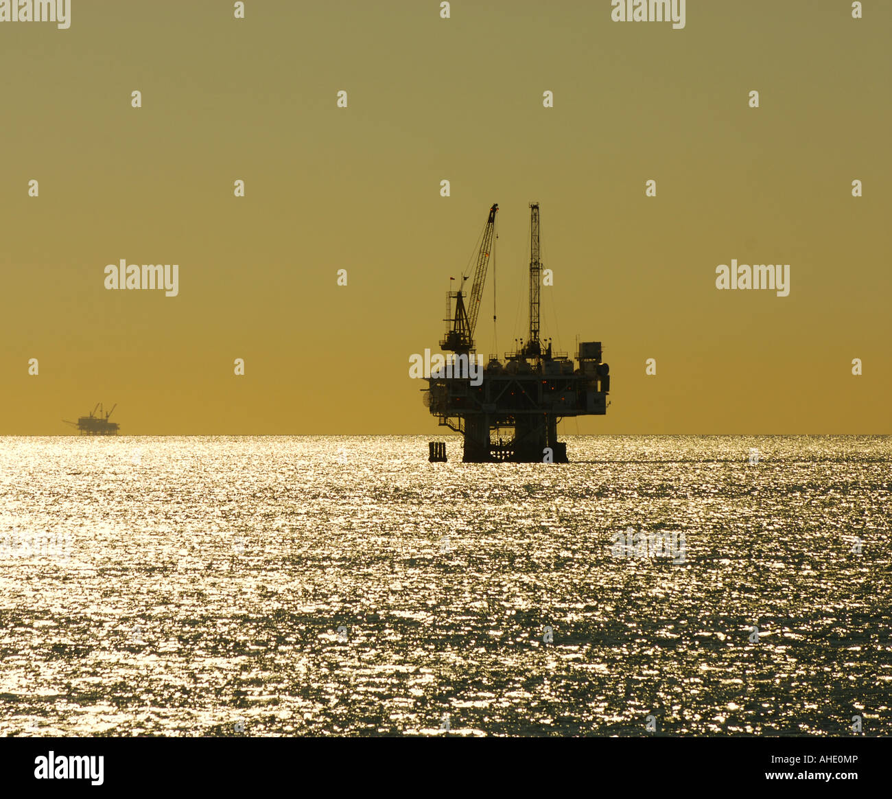 Silhouette of an offshore petroleum oil drilling platform at sunset as viewed from the Seal Beach Pier in Seal Beach, CA, USA Stock Photo