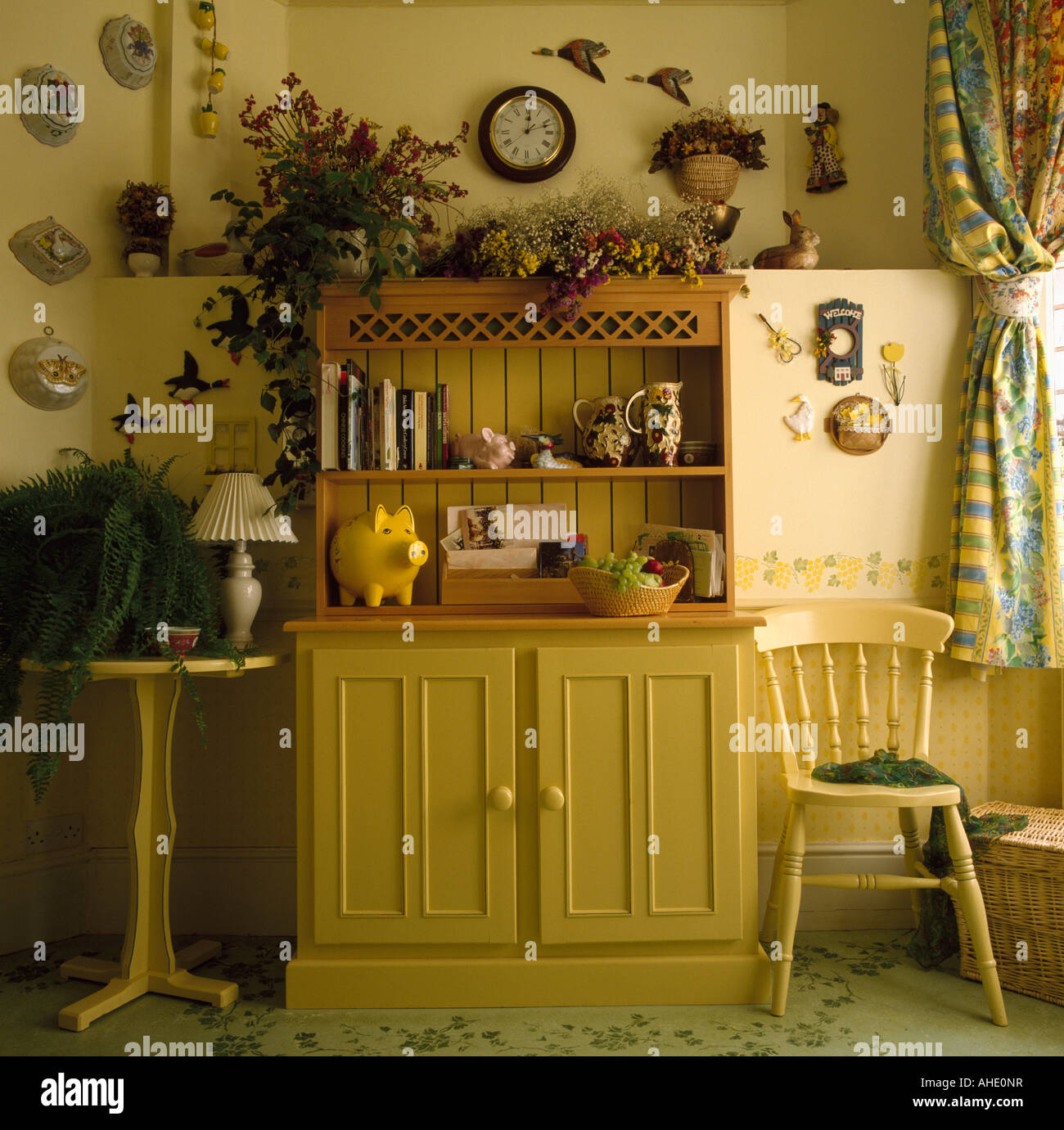 Yellow Painted Dresser And Chair In Corner Of Yellow Dining Room