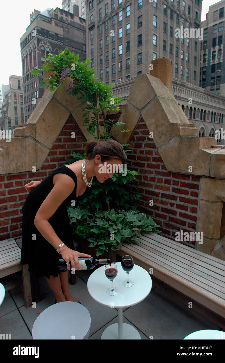 A waitress pours red wine at the Bookmarks Bar in the Library Hotel in