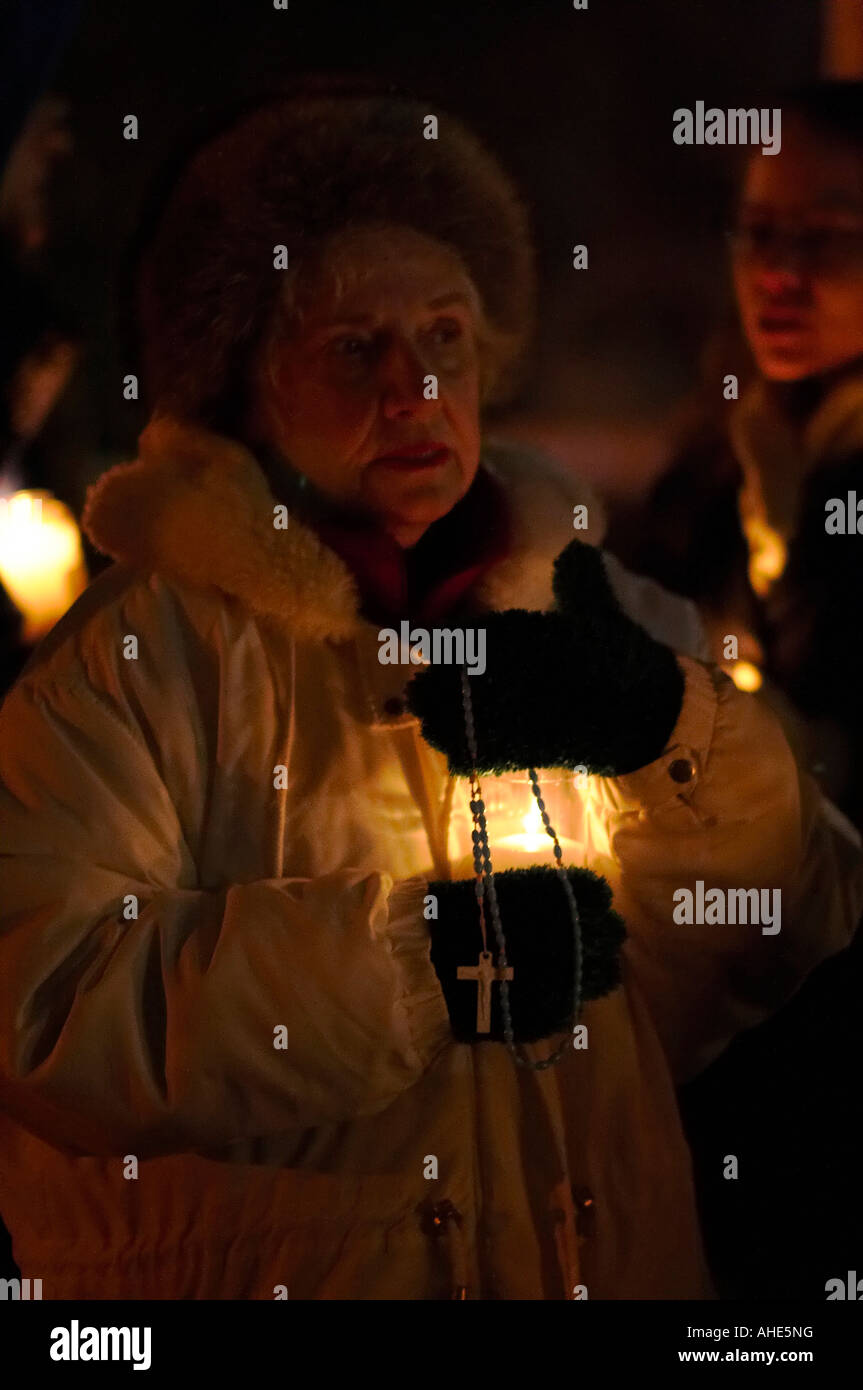 A woman holding a rosary at a candlelight vigil praying for an end to abortion Stock Photo