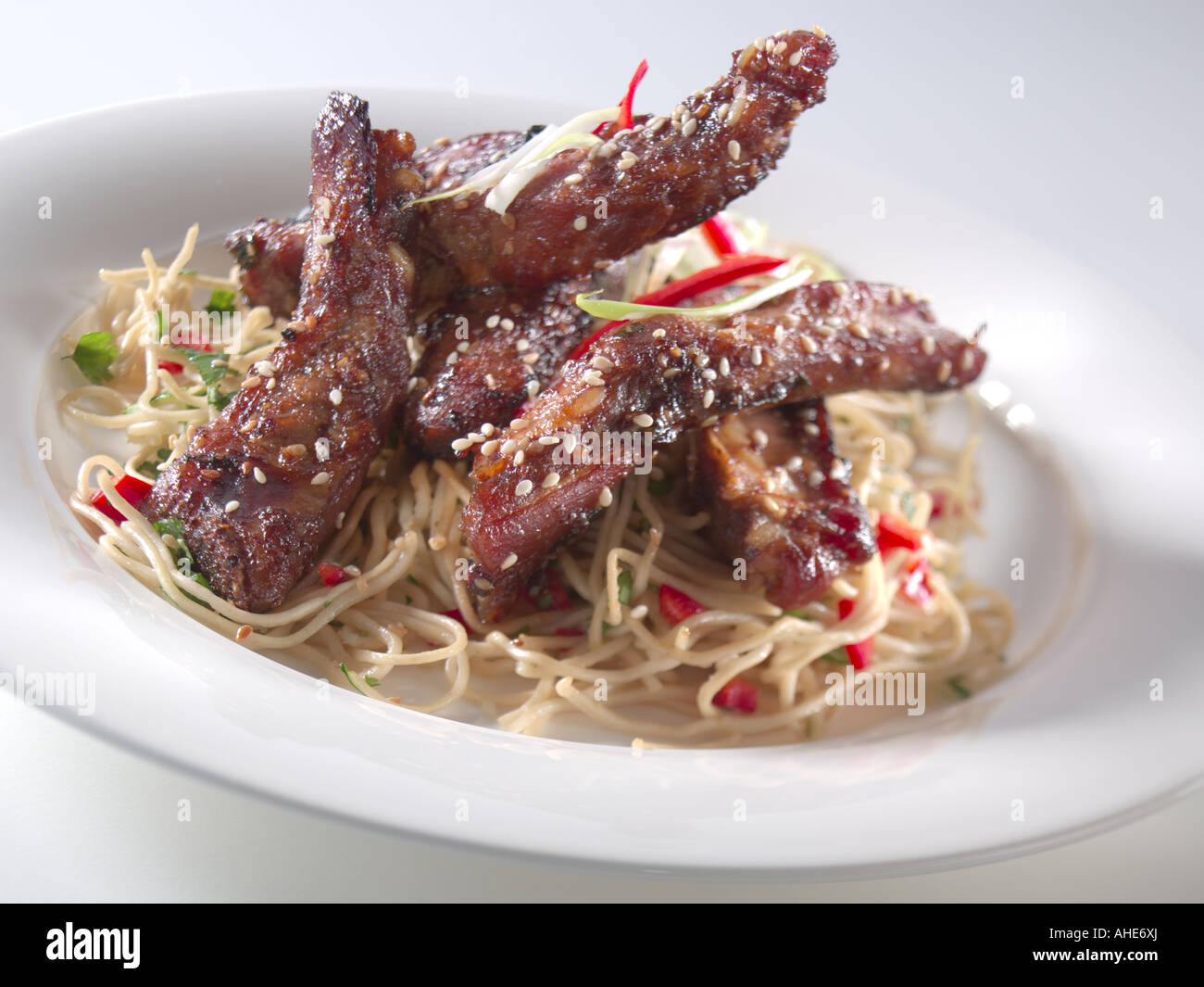 Sticky chinese pork spare ribs sesame seeds noodles hi-res stock ...