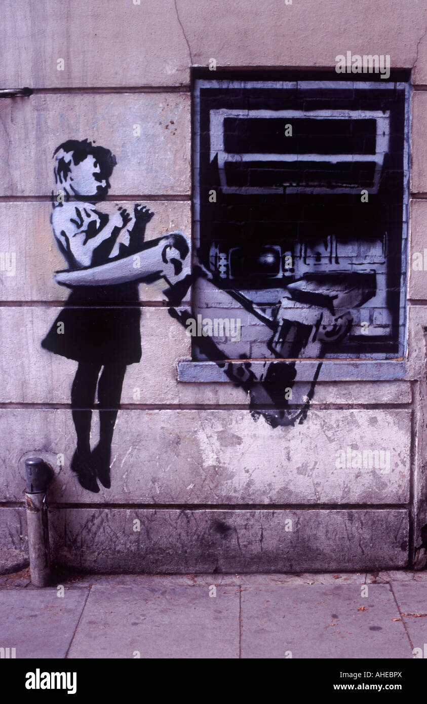 BANKSY Street Stencil Art: Little girl being lifted by mechanical arm emerging from wall cash machine, Clerkenwell, London Stock Photo