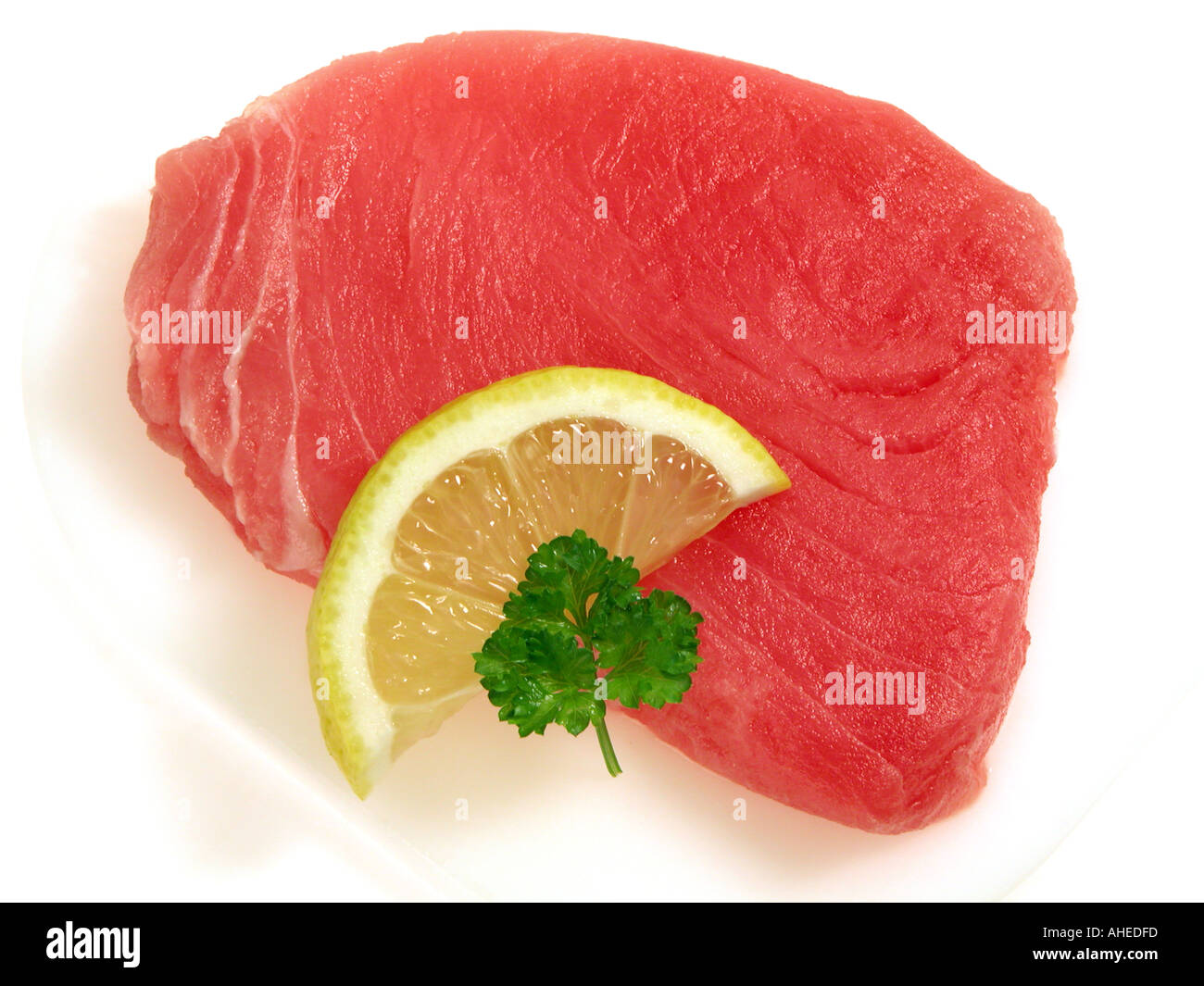 TUNA steak of Thunfisch tunafish fillets sushi quality lemon lime slices parsley Stock Photo