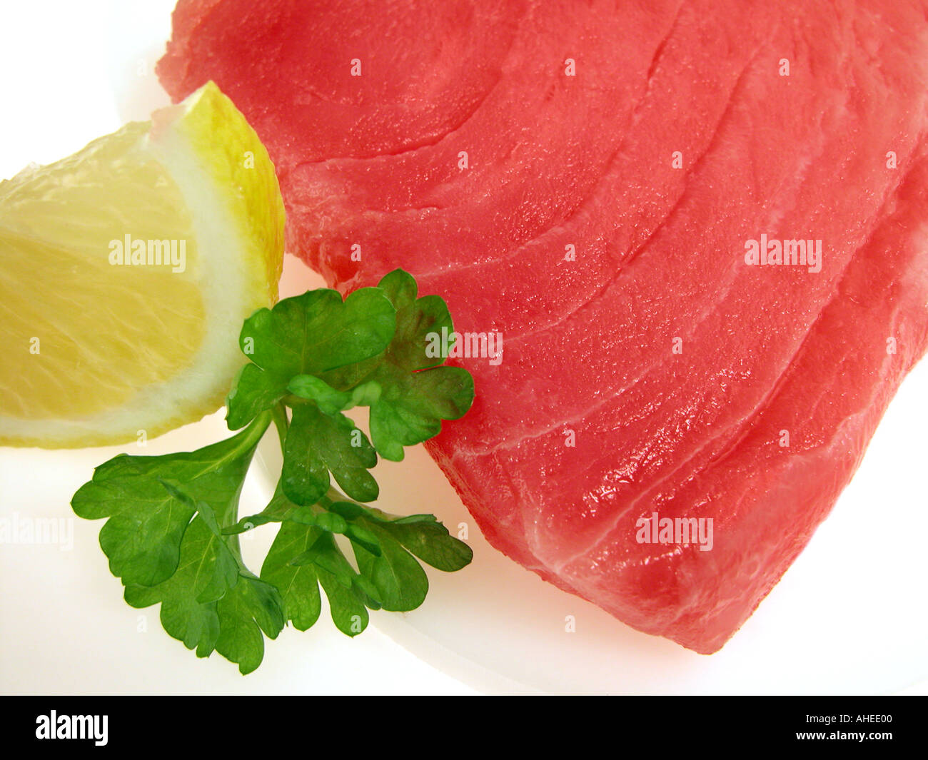 TUNA steak of Thunfisch tunafish fillets sushi quality lemon lime slices parsley thun loin thunnus albacares shashimi sushi Stock Photo