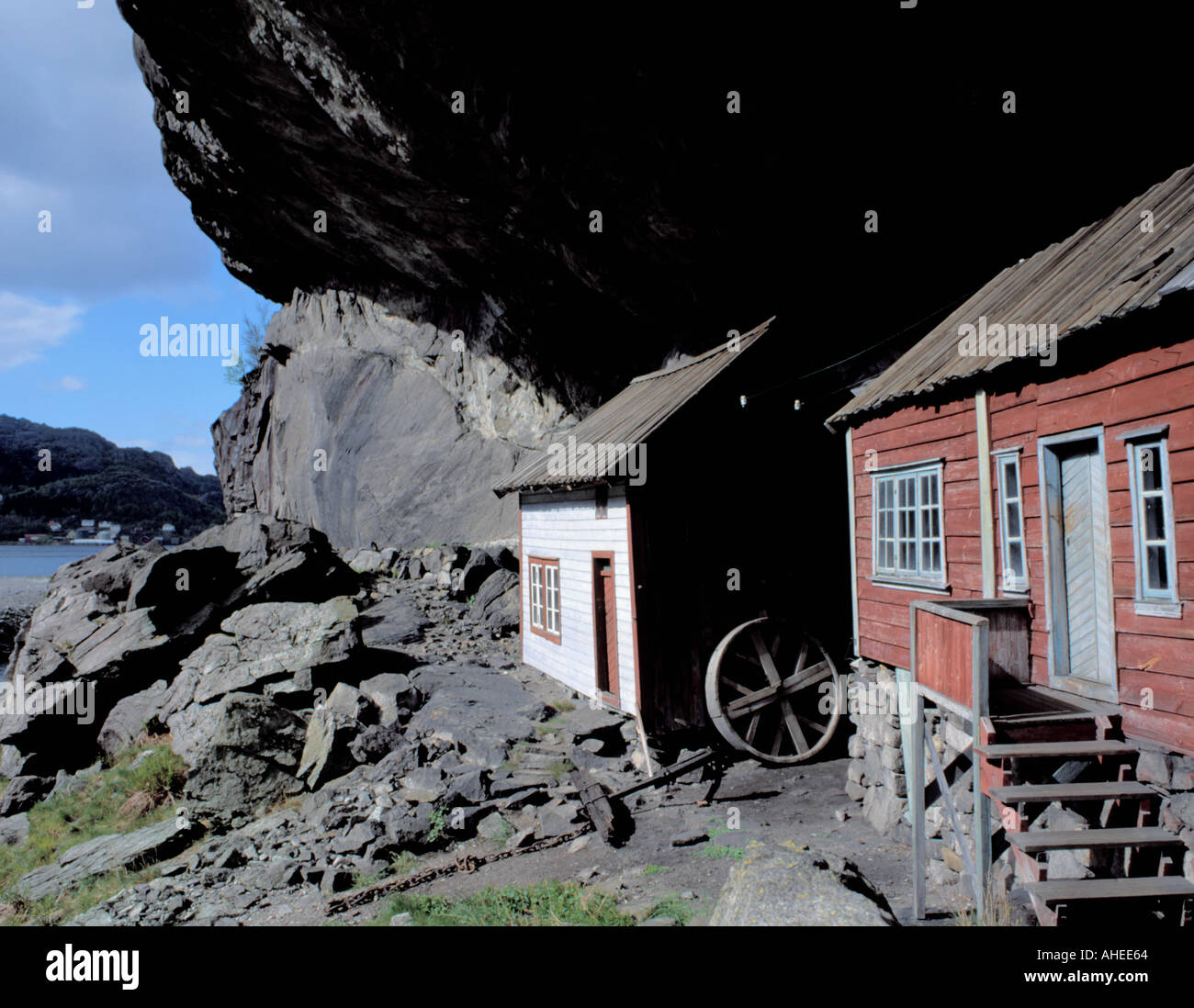 Picturesque old timber houses beneath 'Helleren' (a huge rock overhang), Jøssingfjord, Rogaland, Norway. Stock Photo