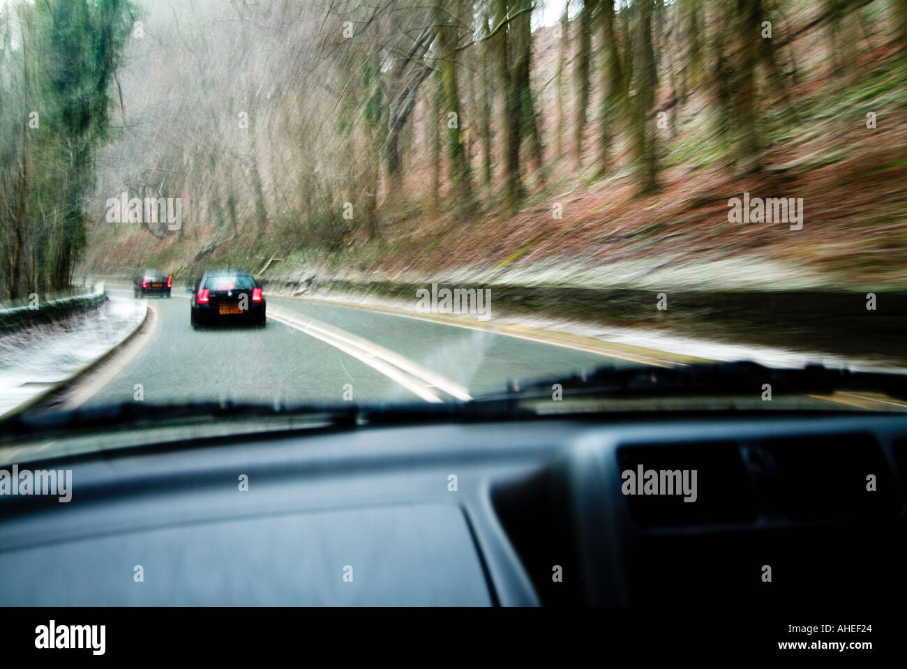 Cars ahead driving through sleet and snow photographed through the windscreen Stock Photo