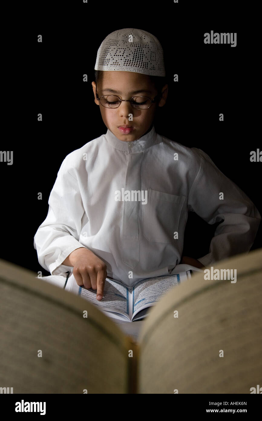 A young boy reading the Qur'an Stock Photo