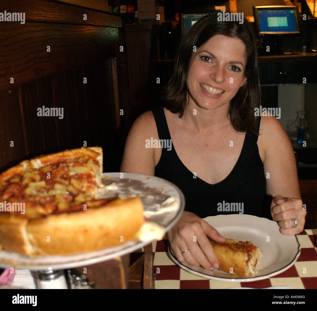 Brunette woman with a deep dish Chicago style pizza at Giordano's Restaurant and Pizzeria in Chicago, Illinois, USA. Stock Photo