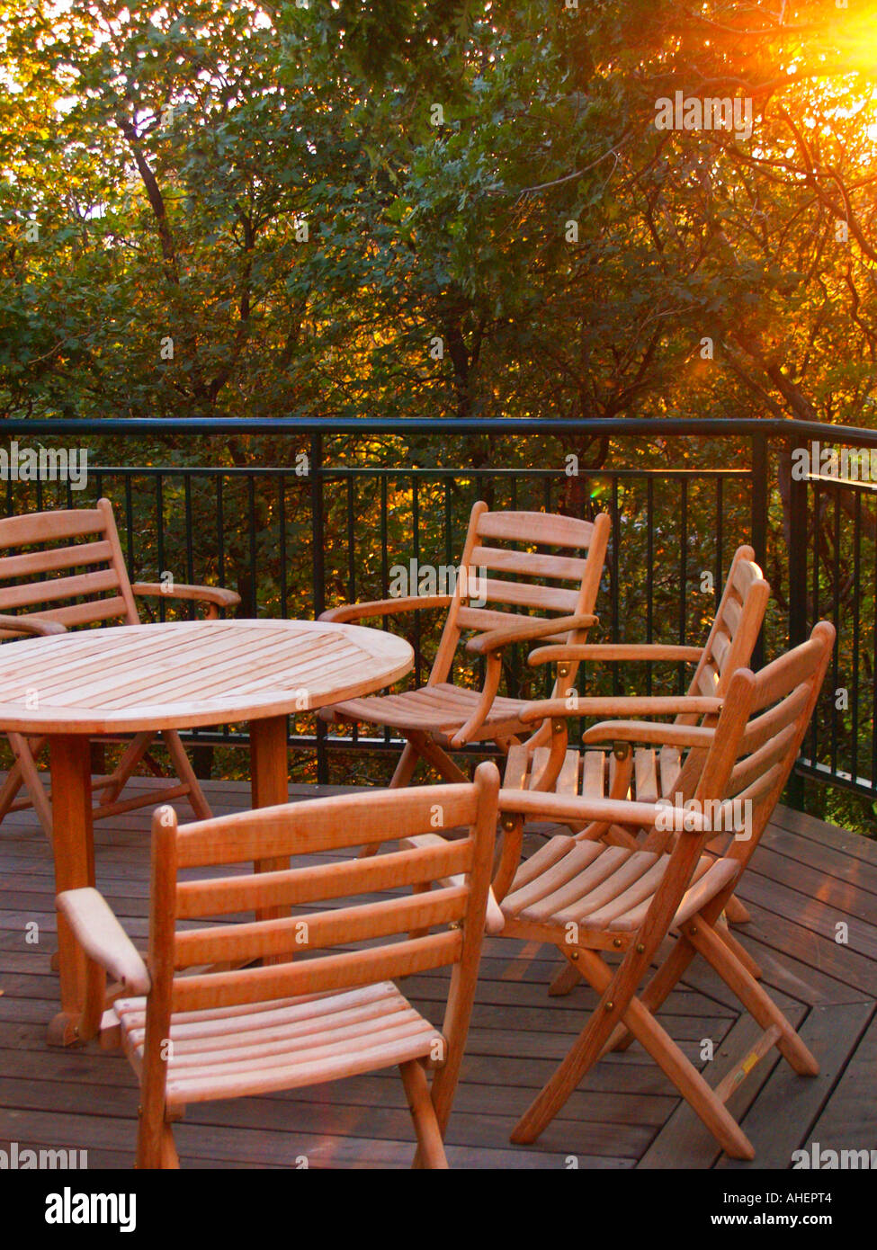 Patio Furniture On A Wooden Patio At Dusk Surrounded By Lush Trees Stock Photo Alamy