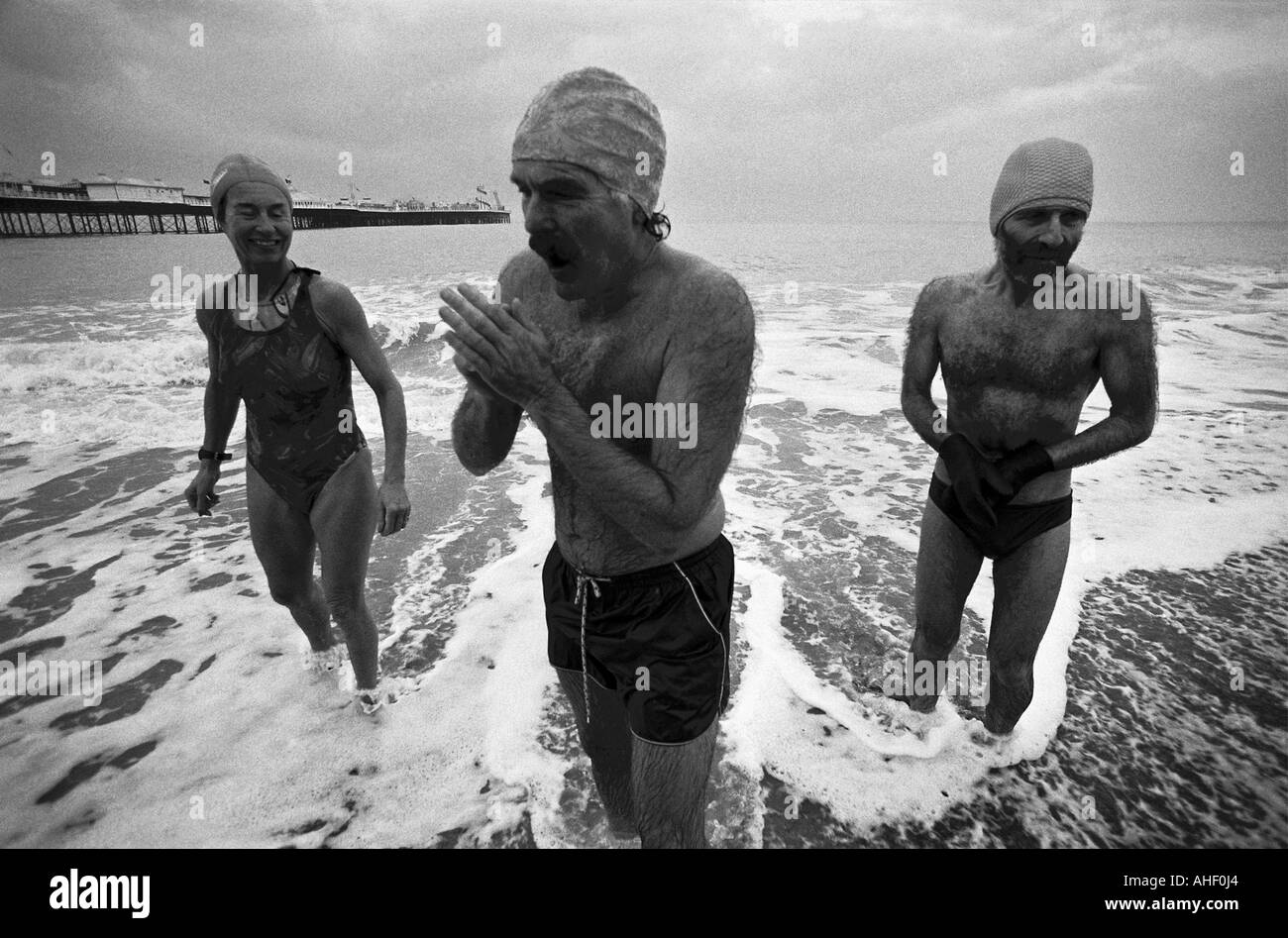 British stiff upper lip being demonstrated by three sea bathers from the Brighton Shiverers in the freezing winter weather. Stock Photo