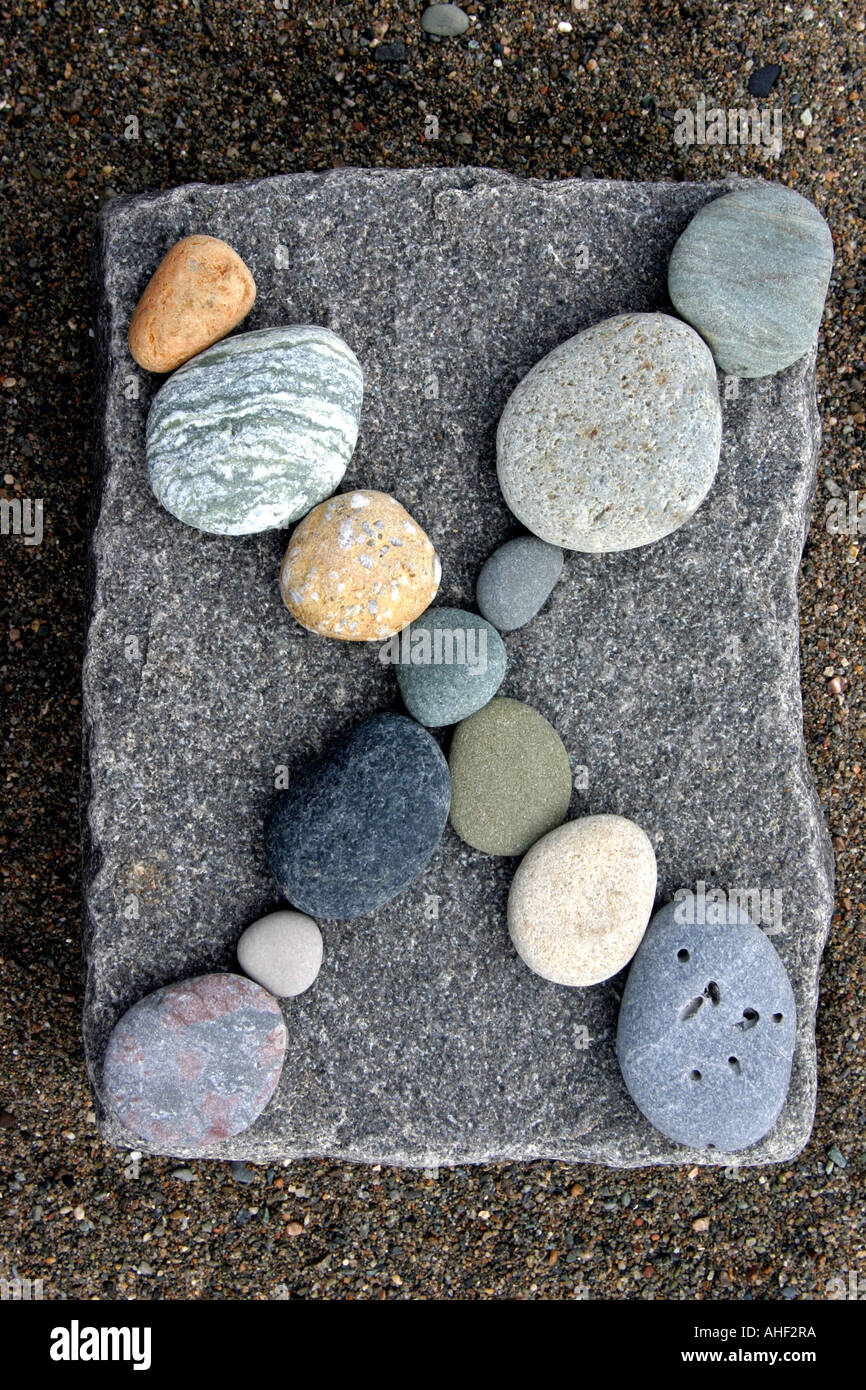 pebbles making an X on a larger square stone Stock Photo