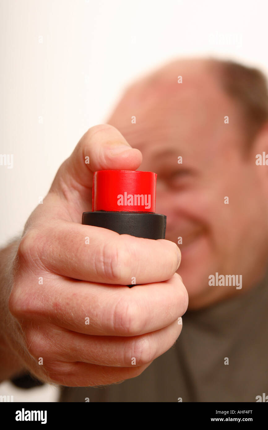 Anxious middle age man about to press red control button Stock Photo