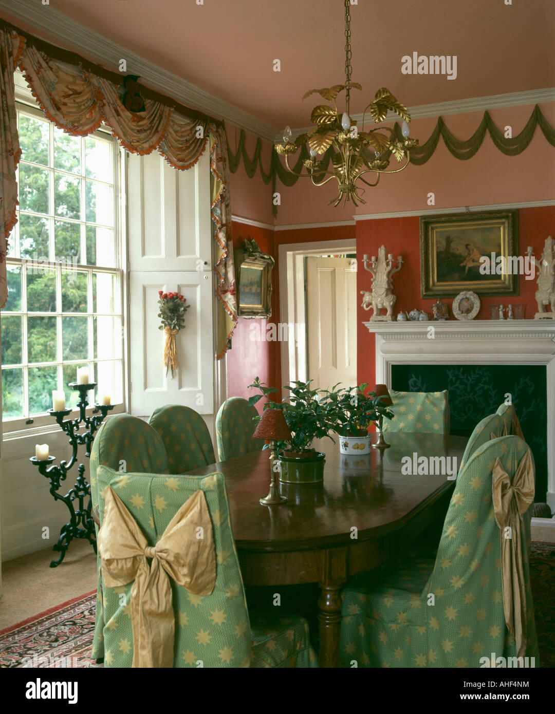 Green loosecovers with bows on chairs in nineties peach dining room ...