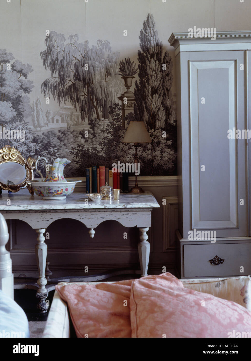 Painted grey console table and cupboard in front of country mural on