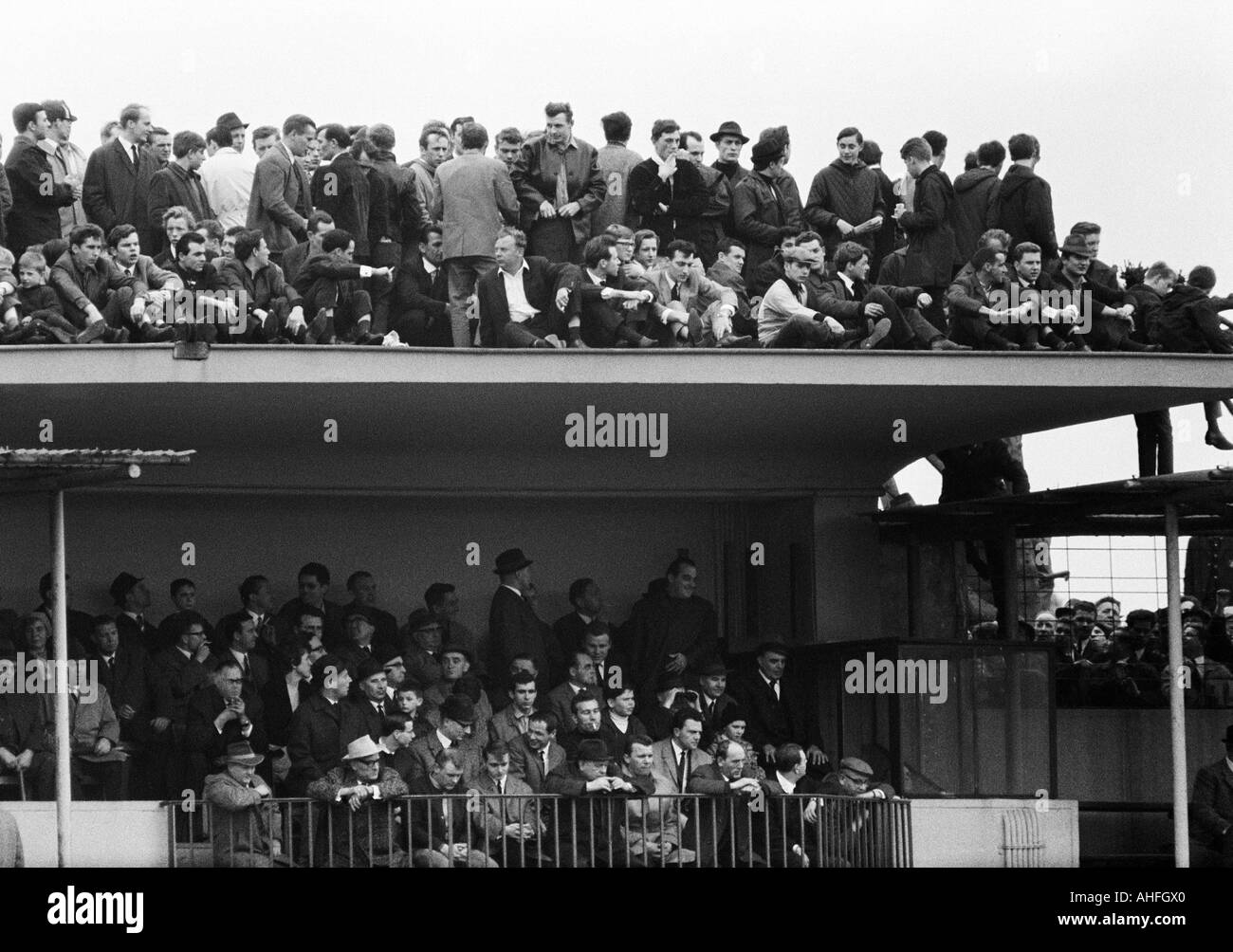 football, Bundesliga, 1965/1966, Meidericher SV versus Borussia Dortmund 2:1, Wedau Stadium in Duisburg, crowd of spectators sitting on a stand roof Stock Photo