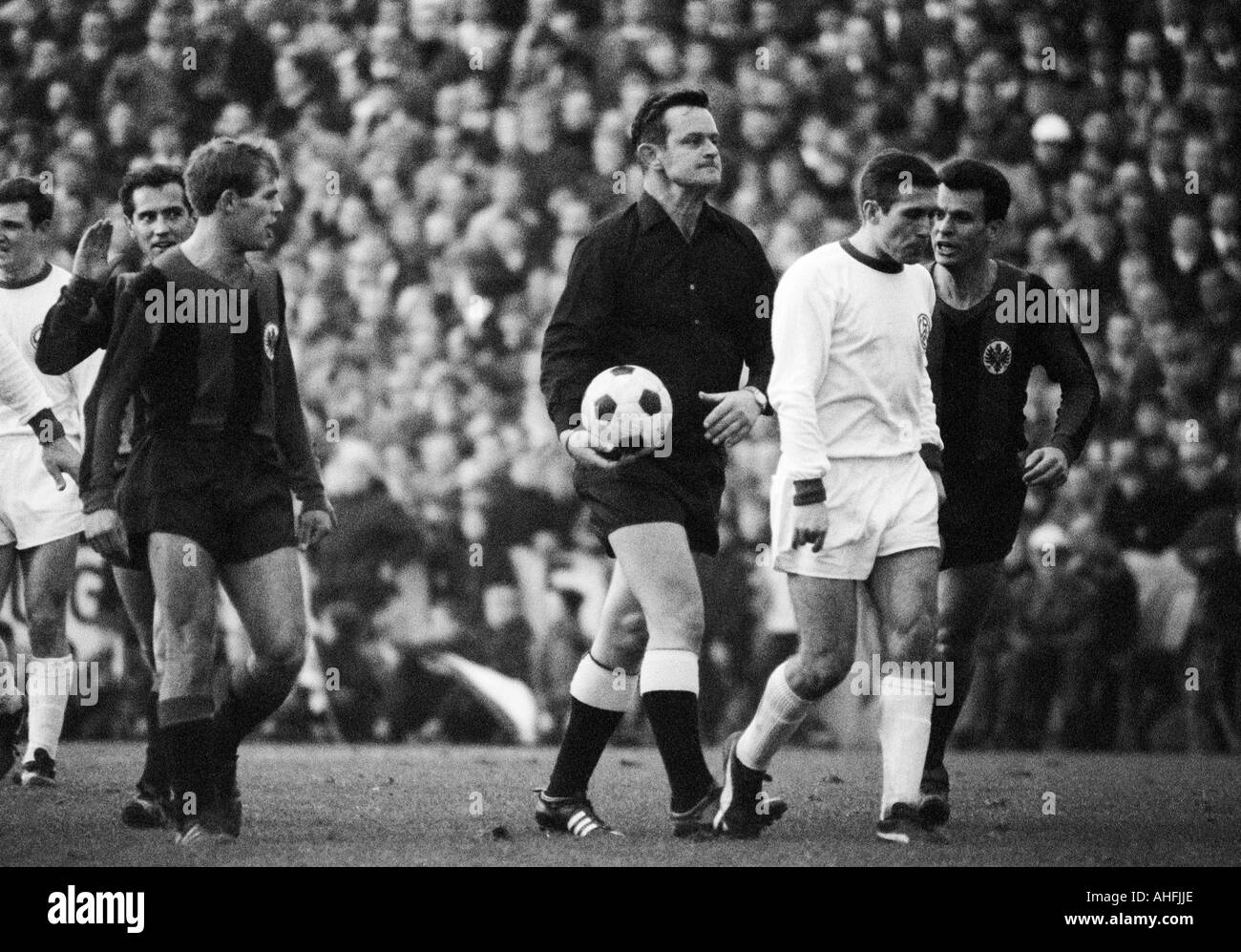football, Bundesliga, 1966/1967, Stadium at the Hafenstrasse in Essen, Rot-Weiss Essen versus Eintracht Frankfurt 1:1, scene of the match, Frankfurt players do not agree to a decision of the referee and try to discuss, f.l.t.r. Willi Lippens (RWE), Wolfga Stock Photo