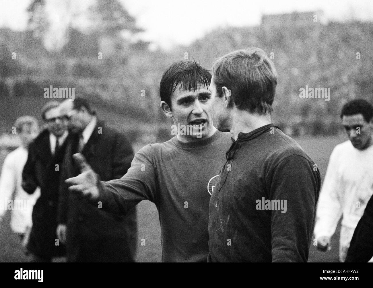 football players leaving the pitch, Karl Heinz Ferschl (Nuernberg) left ahead in discussion with keeper Roland Wabra (Nuernberg), left behind coach Max Merkel (Nuernberg), right behind Werner Waddey (MG) Stock Photo