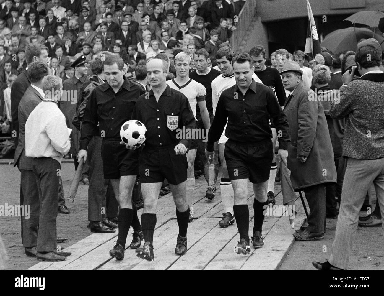 football, Bundesliga, 1968/1969, Borussia Dortmund versus Borussia Moenchengladbach 1:3, Stadium Rote Erde, teams come in the Rote Erde Stadium, ahead the match officials with referee Rudolf Kreitlein from Stuttgart (middle), behind f.l.t.r. team captain Stock Photo