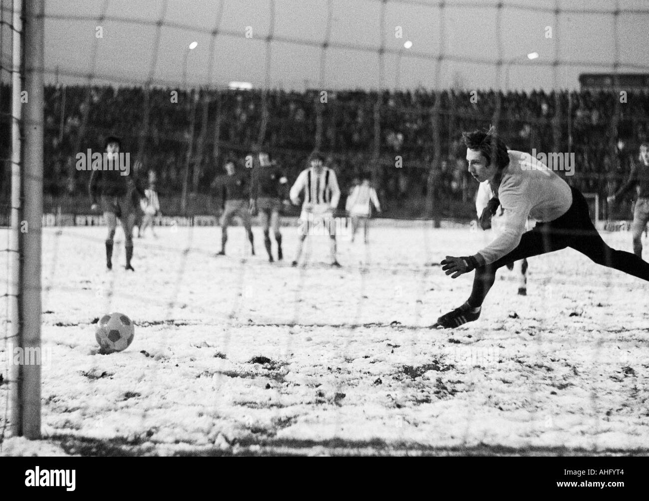 football, DFB Cup, eighth final, 1973/1974, Borussia Moenchengladbach versus Hamburger SV 2:2 after extra time, Boekelberg Stadium in Moenchengladbach, game on snow ground, scene of the match, keeper Rudolf Kargus (HSV) in luck Stock Photo
