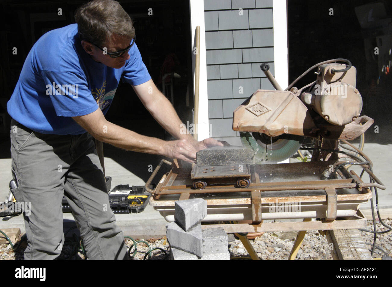 Worker using concrete cutting saw to cut pavers Stock Photo Alamy