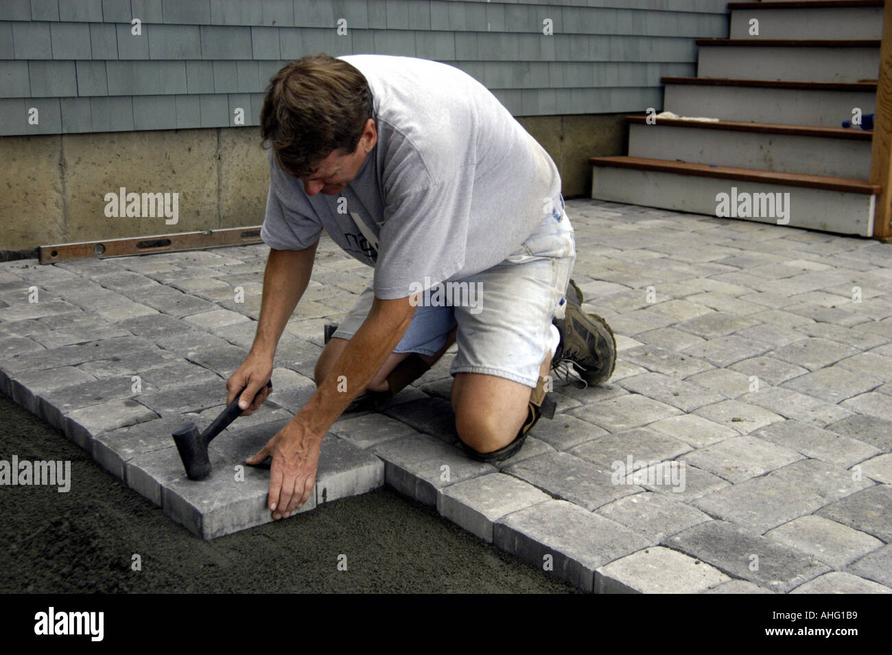 Working laying concrete pavers for patio Stock Photo Alamy