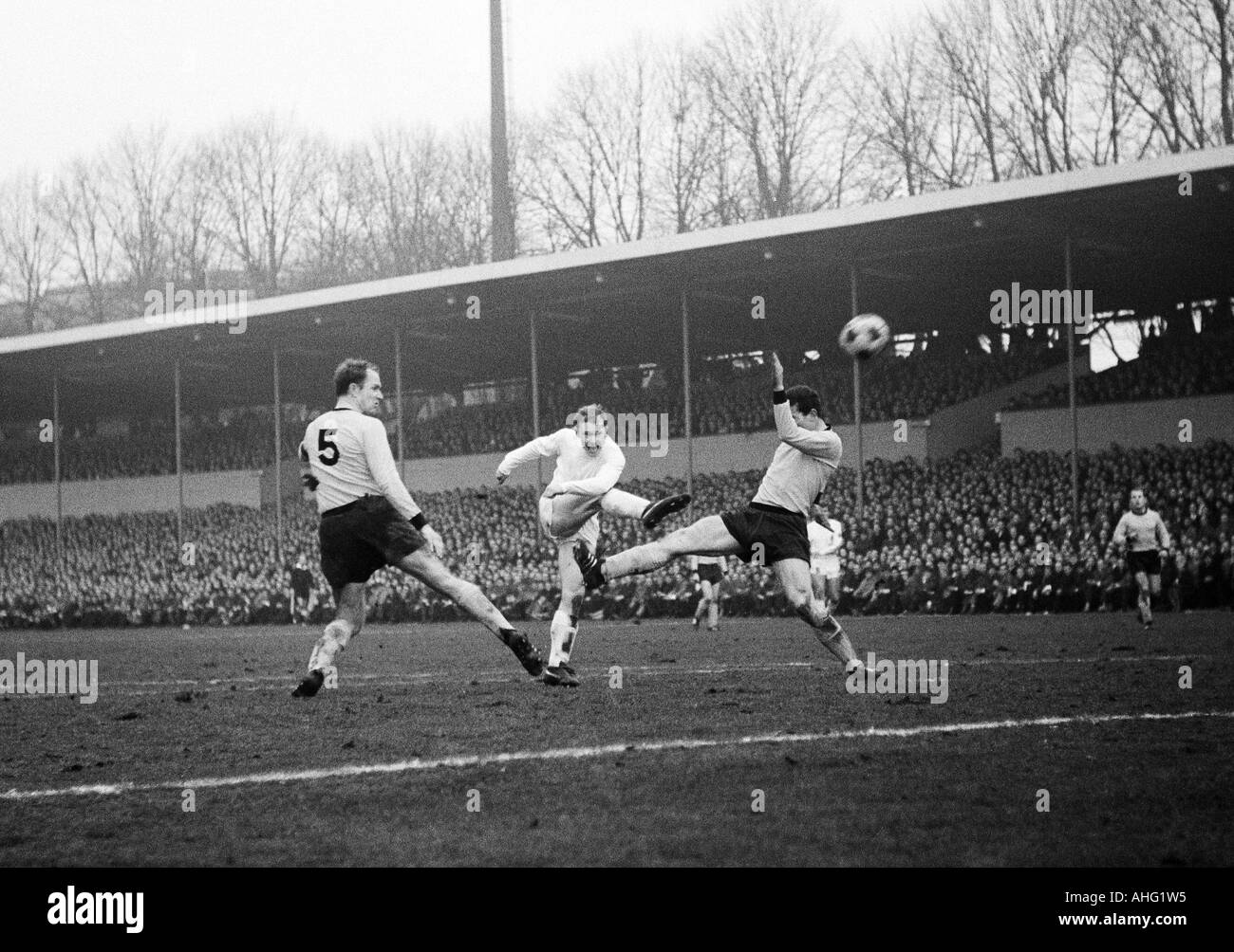 football, Bundesliga, 1966/1967, Borussia Dortmund versus Borussia Moenchengladbach 3:2, Stadium Rote Erde in Dortmund, scene of the match, f.l.t.r. Wolfgang Paul (BVB), Bernd Rupp (Gladbach) shots on goal, Gerd Peehs (BVB) Stock Photo