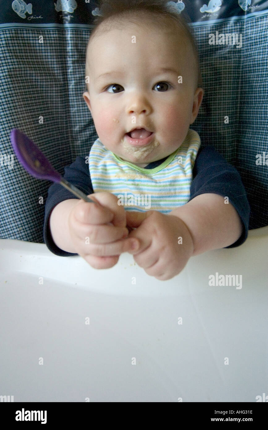 baby eating at high chair Stock Photo Alamy