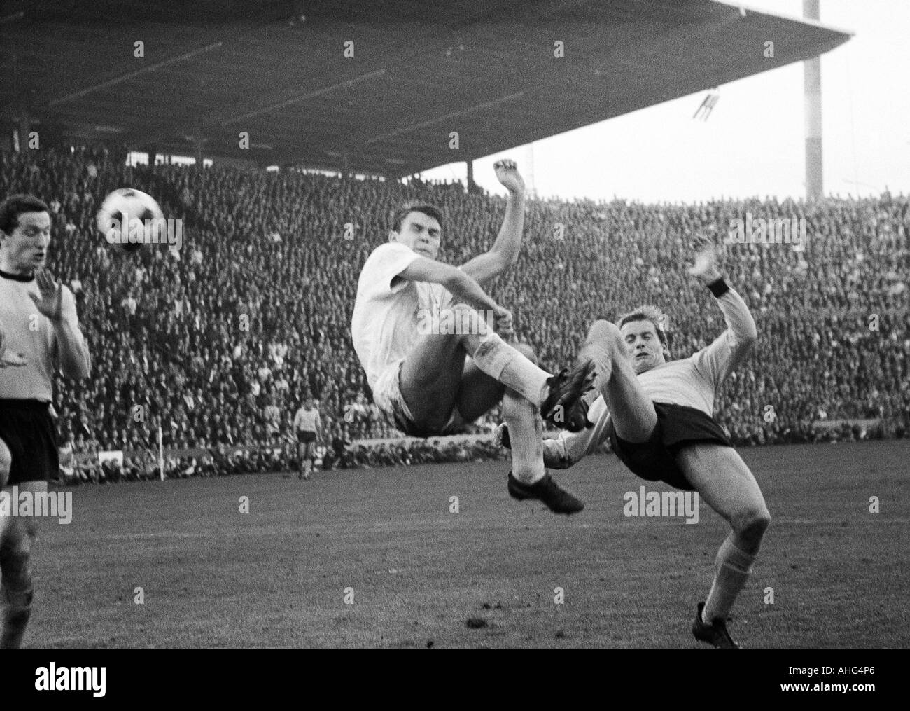 football, Bundesliga, 1967/1968, Borussia Moenchengladbach versus Borussia Dortmund 2:2, Boekelberg Stadium, scene of the match, acrobatic feat by Herbert Laumen (Gladbach) middle and Theodor Redder (Dortmund) right, left Gerd Peehs (Dortmund) Stock Photo