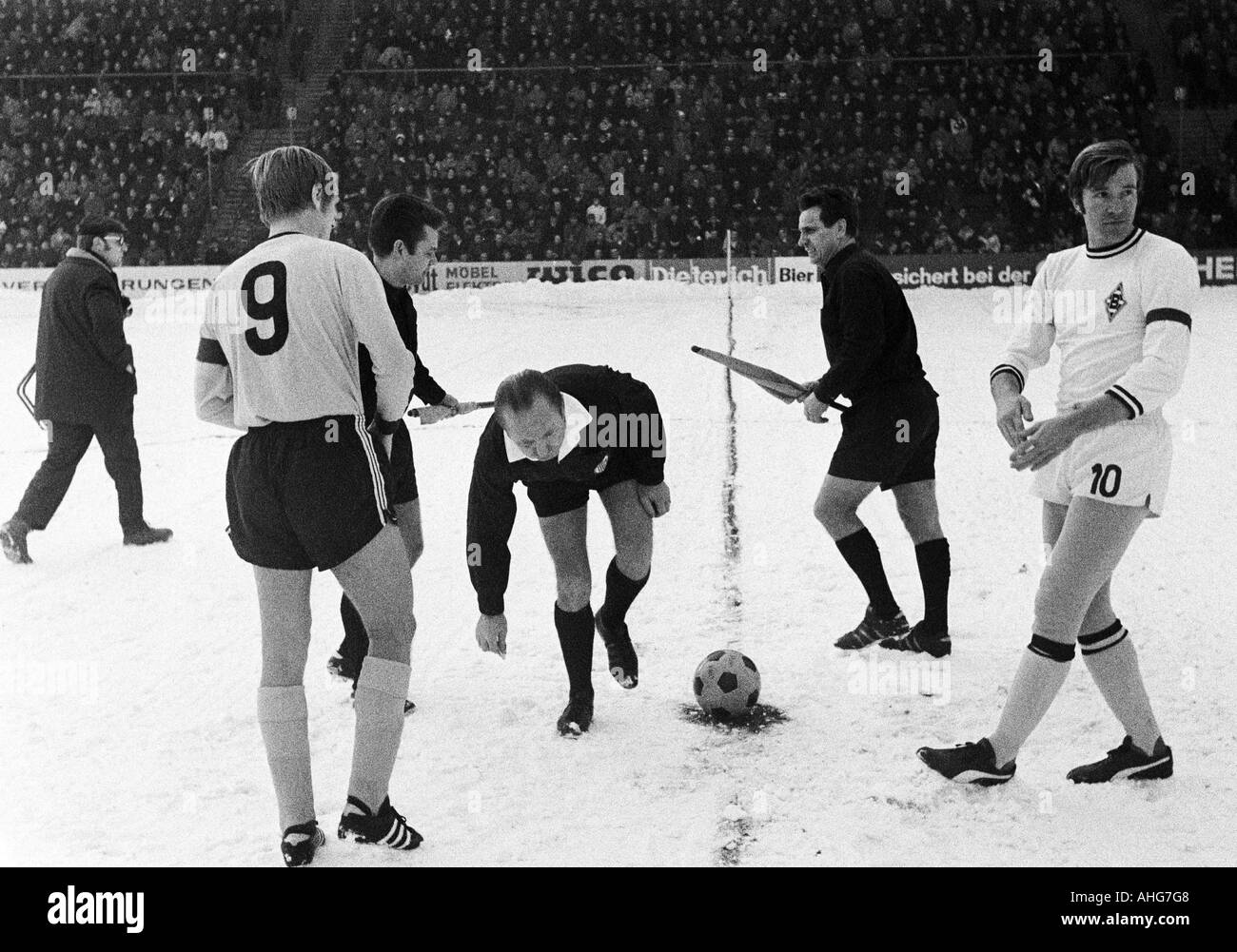 football, Bundesliga, 1969/1970, Borussia Moenchengladbach versus Borussia Dortmund 4:2, Boekelberg Stadium, match on snow ground, toss-up and welcome, team captains Siegfried Siggi Held (Dortmund) left and Guenter Netzer (Gladbach), referee Anton Binder Stock Photo