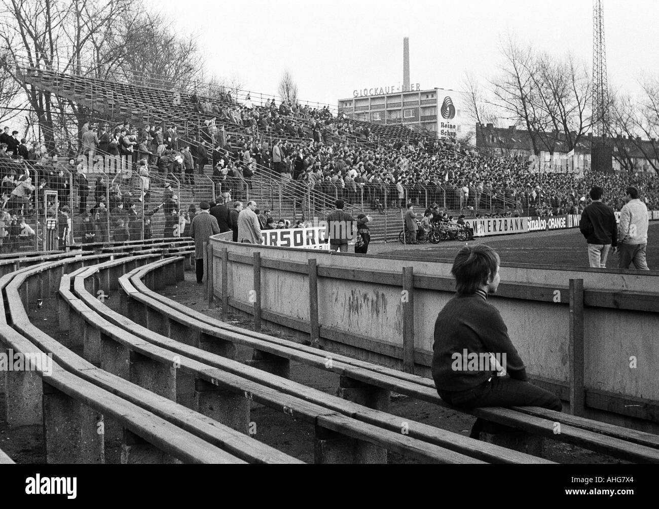 football, Bundesliga, 1969/1970, FC Schalke 04 versus Rot-Weiss Oberhausen 2:2, Glueckaufkampfbahn Stadium in Gelsenkirchen, few spectators in the stadium, young boy sits on a wooden bench Stock Photo