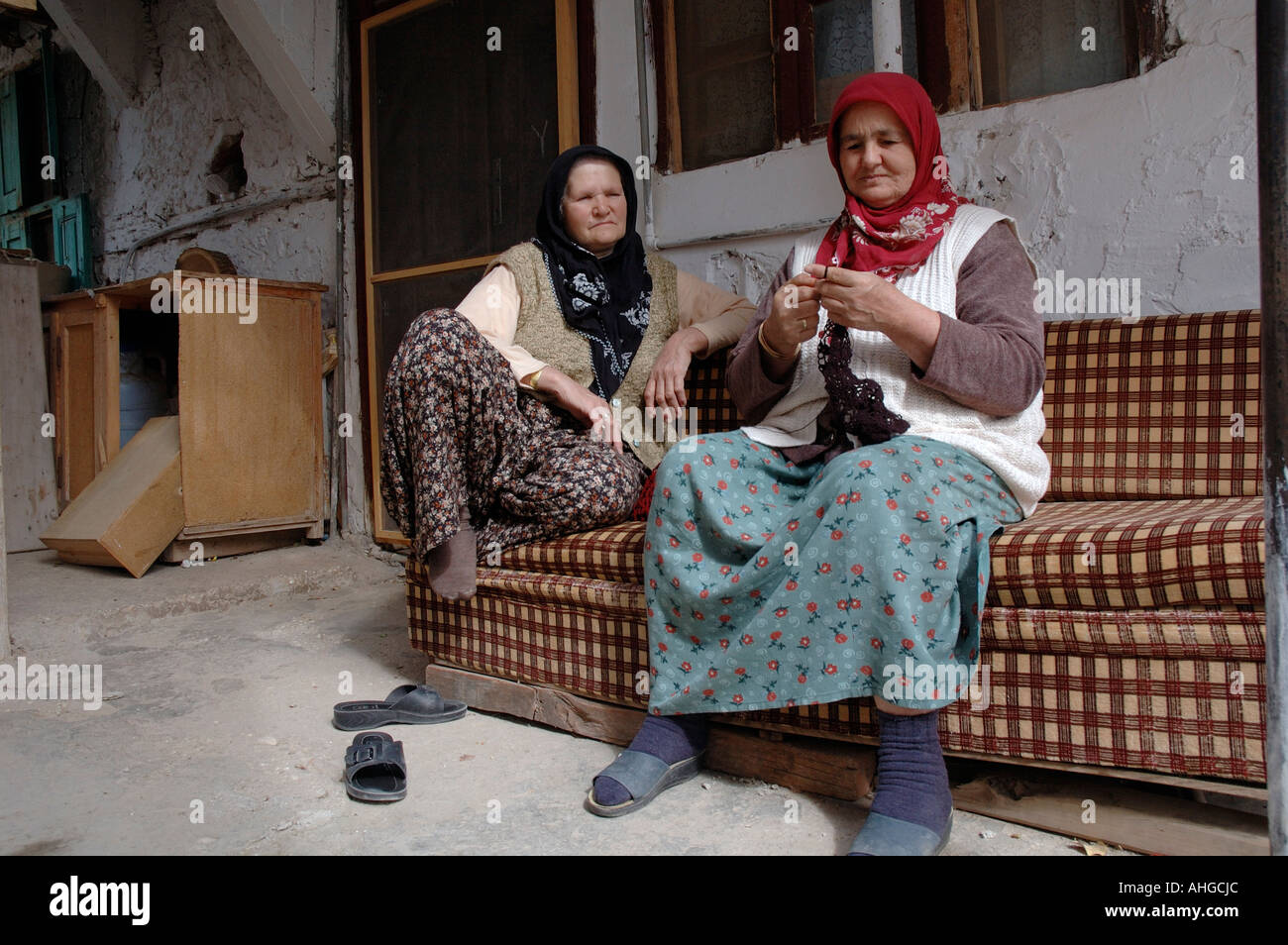 Women knitting and lacemaking in side street in Kalcan in Southern Turkey. Stock Photo
